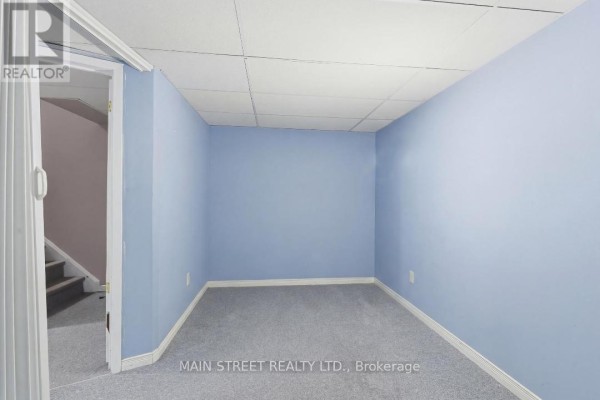 Finished basement room with blue walls, grey carpet, drop ceiling - 2 - 110 Silvan Drive, Welland