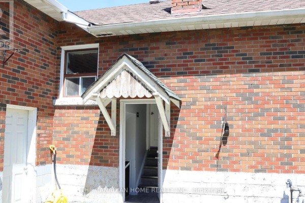 Exterior view of red brick house with a small white awning over doorway. - 2 - 113 Pitfield Road, Toronto