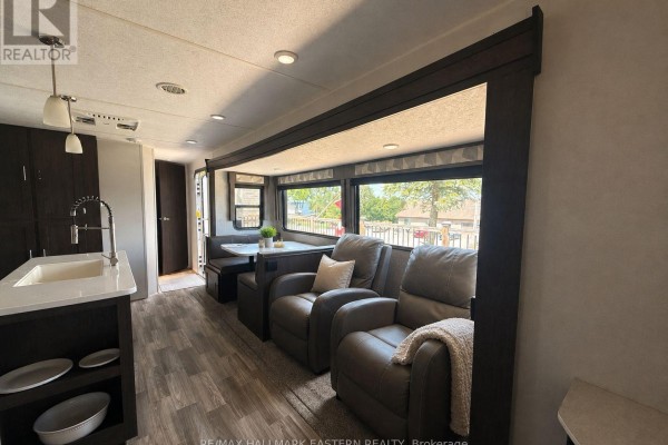 RV living area with recliner chairs, dining booth, and large windows overlooking the outside. - #2 - 1280 Gail Park Drive N, Selwyn