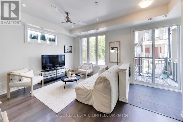 Modern kitchen with white cabinetry, granite countertops, stainless steel appliances, and island seating. - 2 - 130 Long Branch Avenue, Toronto
