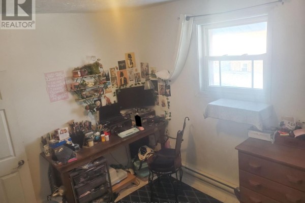Living room with a brown sectional sofa, two televisions, and plush toys on the floor. - 2 - 134 Simcoe Street S, Oshawa