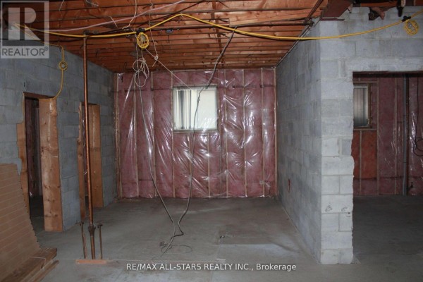 Unfinished basement room with cinder block walls, exposed ceiling, and insulation in some areas. - 2 - 183 Simcoe Avenue, Georgina