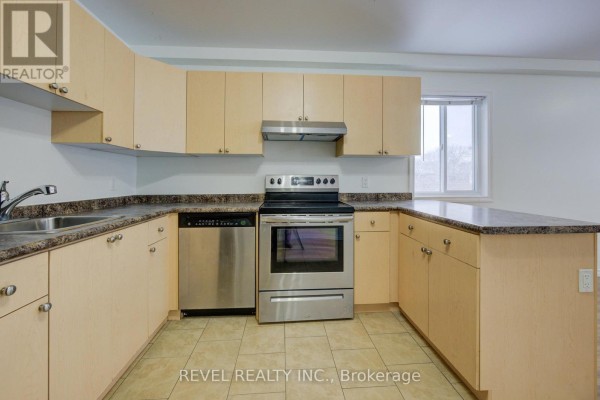 Kitchen with light wood cabinets, granite countertops, and stainless steel appliances. - 2 - 20 Puleston Street, Brantford