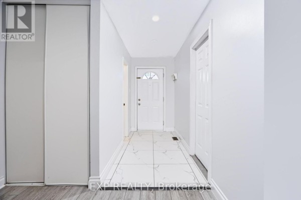 Hallway interior with white front door and tiled floor leading to rooms. - 2 - 2669 Southvale Crescent E, Ottawa