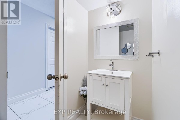 Powder room with a white vanity, sink, mirror, and decorative light fixture. - 2 - 2669 Southvale Crescent E, Ottawa