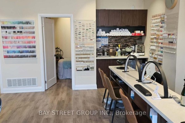 Nail salon interior showing manicure stations, polish displays, and a treatment room entrance. - 2 - 2671 Bur Oak Avenue, Markham