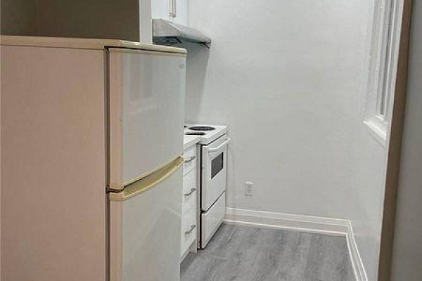 A small kitchen area with a white refrigerator, white stove, and white cabinets. - 2 - 271 Dunn Avenue, Toronto