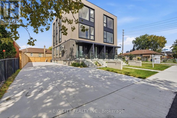 Concrete driveway and walkway lead to modern townhouse entrances with glass railings. - 2 - 276 Lanor Avenue, Toronto