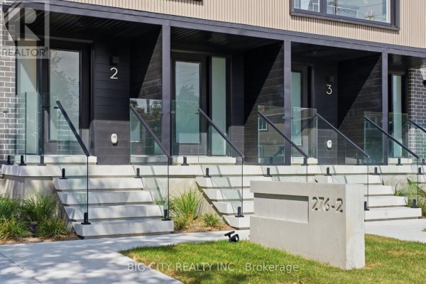Detailed view of townhouse entrances 2 and 3, featuring glass balconies and concrete steps. - 2 - 276 Lanor Avenue, Toronto
