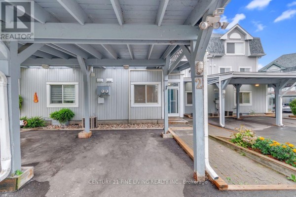 Covered parking area and exterior entrance of a townhouse. - 2 - 30 Laguna Parkway, Ramara