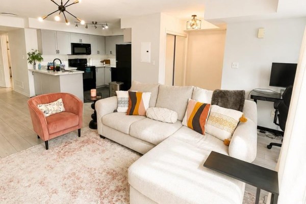 Living room with a large sectional sofa, dining area, and kitchen. - 2 - 35 Hays Boulevard, Oakville