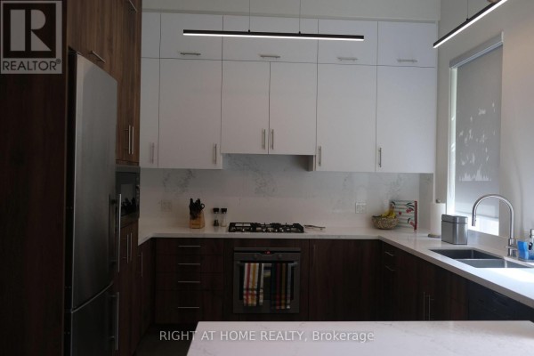 Modern kitchen with dark wood and white cabinets, stainless steel appliances. - 2 - 41 Spruce Street, Toronto
