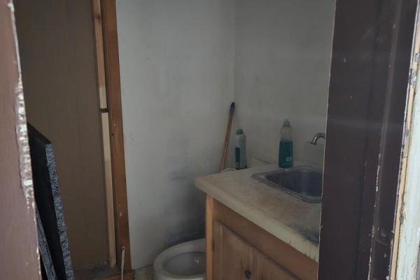 Small bathroom with toilet, sink, and wooden vanity cabinet. - 2 - 5126 Victoria Avenue, Niagara Falls