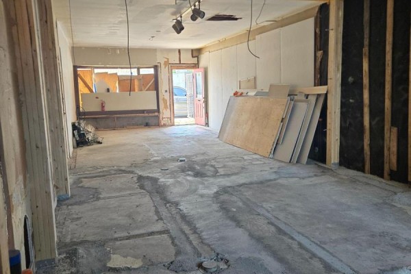 View of an empty commercial space with concrete floor and construction materials. - 2 - 5126 Victoria Avenue, Niagara Falls