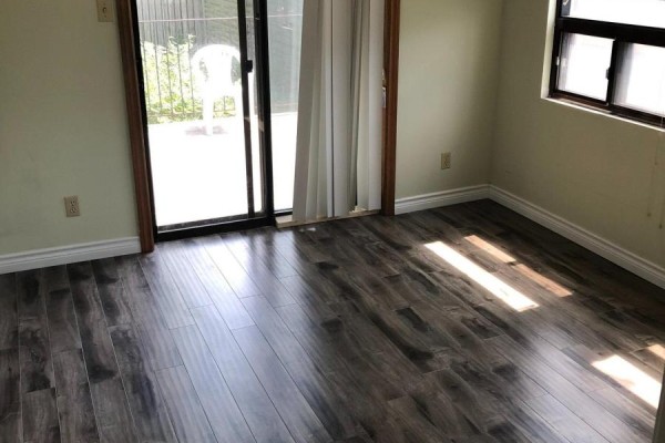 Bedroom with laminate flooring, pale green walls, and a sliding glass door to an outdoor space. - 2 - 54 Markham Street, Toronto