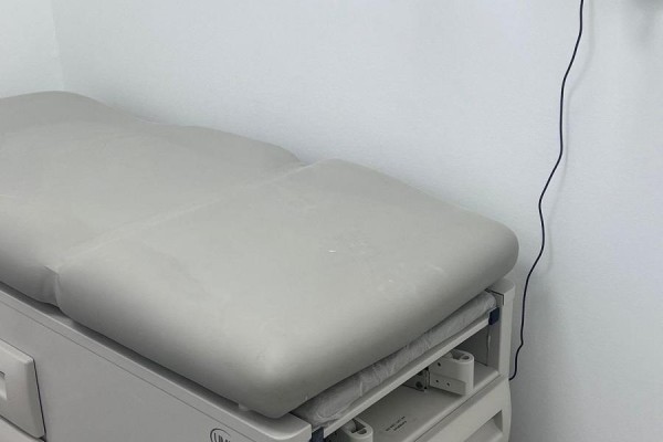 Close-up view of a light gray medical examination table in an exam room. - 2 - 5694 Highway 7 Highway E, Markham