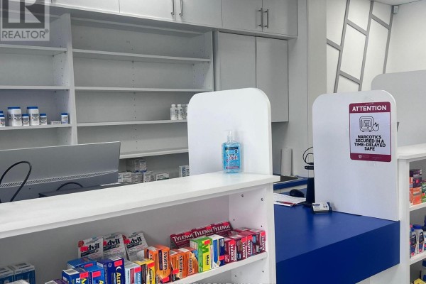 Pharmacy counter with shelves of medications, hand sanitizer, and a computer. - 2 - 5694 Highway 7 Highway E, Markham