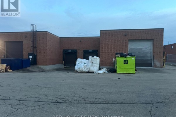 Rear exterior of commercial building with three loading docks, two large roll-up doors, and waste bins. - 2 - 60 Haist Avenue, Vaughan