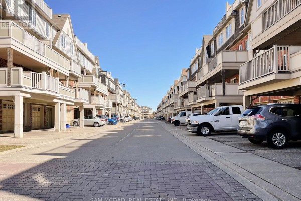 Rear view of townhouses with garages, driveways, and balconies. - 2 - 639 Dundas Street W, Mississauga