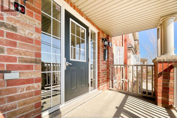 Front door with glass panels and sidelights on a covered porch. - 2 - 639 Dundas Street W, Mississauga