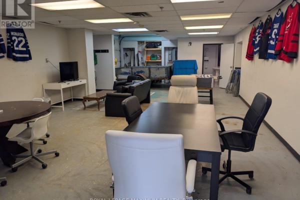 Office space with a large L-shaped desk, computers, and a window overlooking a parking lot. - 2 - 644 Millway Avenue, Vaughan