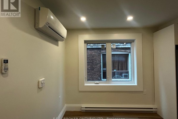 Close-up of kitchen sink, white cabinets, countertops, and window overlooking backyard. - 2 - 659 Vaughan Road, Toronto