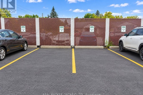 Outdoor parking lot with designated tenant parking spaces marked with yellow lines and signage. - 2 - 6610 Fourth Line Road, Ottawa