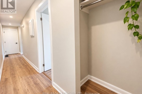 Interior hallway with light wood-look laminate flooring, white doors, and closet space. - 2 - 6610 Fourth Line Road, Ottawa