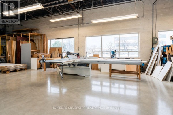 Interior workshop with woodworking equipment and large windows - 2 - 70 Belfield Road, Toronto