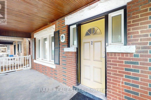 Close up of the front entrance with a yellow door and brick facade. - 2 - 8 Balsam Avenue N, Hamilton