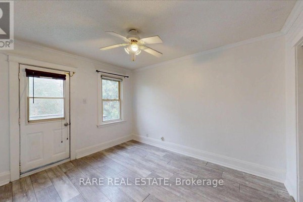 Room with white walls, light wood laminate flooring, a door, and a window. - 2 - 8 Balsam Avenue N, Hamilton