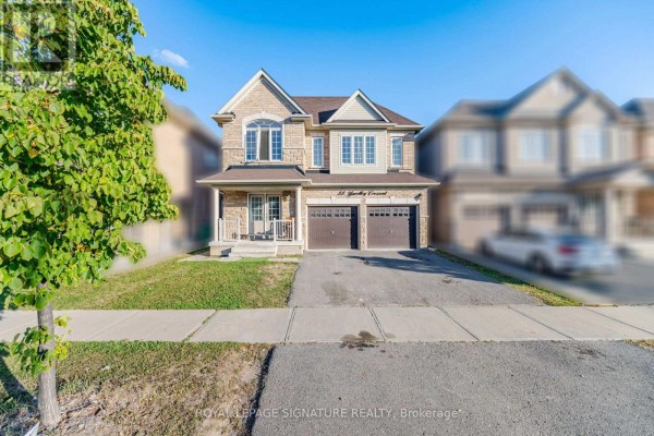 Wide view of the stone and vinyl siding house with a driveway, lawn, and sidewalk. - 2 - 88 Yardley Crescent, Brampton