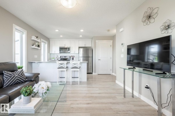 Kitchen with white cabinetry, stainless steel appliances, and breakfast bar - #2 1203 163 St Sw, Edmonton