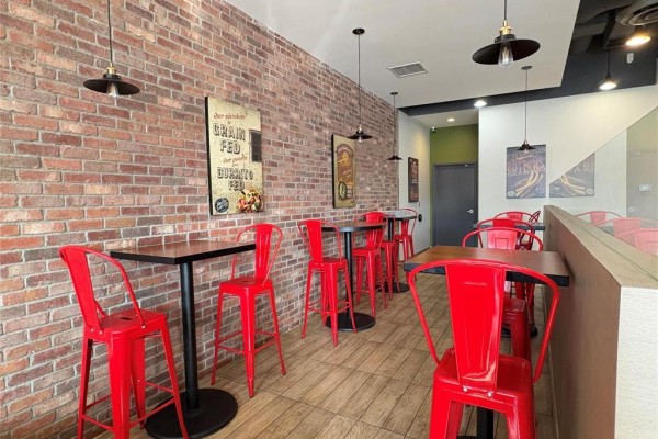 Casual dining space featuring exposed brick walls and high tables - 2 1510 Plessis Road, Winnipeg