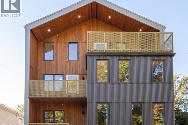 Close-up of townhouse exterior featuring wood and corrugated metal siding. - 2 1721 Adanac St, Victoria