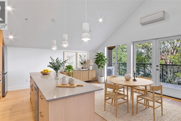 Open concept living area with island, dining table, and patio doors. - 2 1721 Adanac St, Victoria
