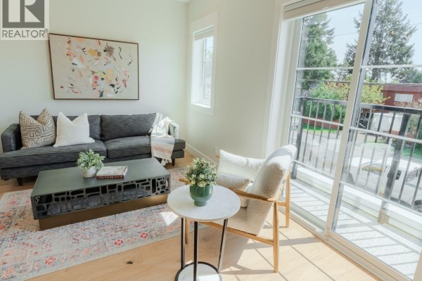 View of kitchen island, living area, and stairs leading to the upper level. - 2 1830 Allenby St, Saanich
