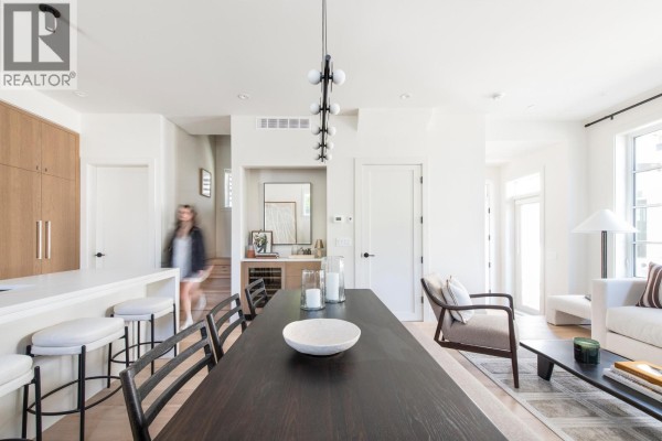 Dining table and chairs with a view of the kitchen and living area. - 2 2119 W 18th Avenue, Vancouver