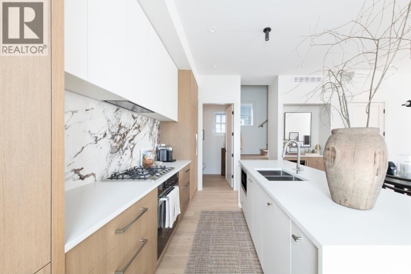 Kitchen area with a gas stove, marble backsplash, and a large island. - 2 2119 W 18th Avenue, Vancouver