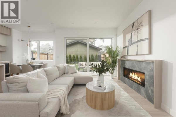 Cozy living area featuring a fireplace, sectional sofa, and garden view - 2 2755 W 11th Avenue, Vancouver