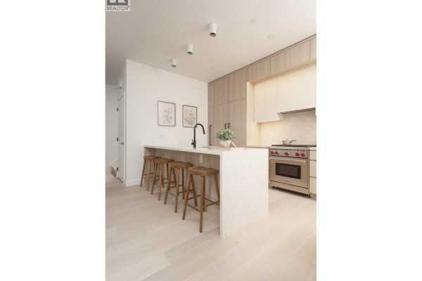 Kitchen with marble countertops, stainless steel appliances, and bar seating - 2 2755 W 11th Avenue, Vancouver