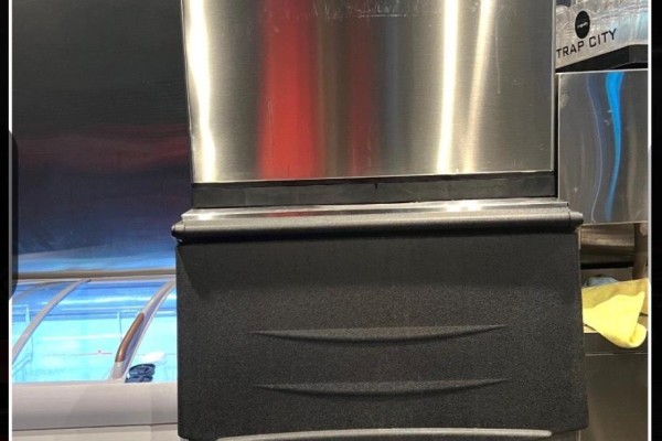 Stainless steel ice machine with a black base next to a glass display case. - 2-3 - 5235 Steeles Avenue W, Toronto