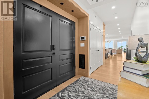 Hallway with light wood floors, black double doors, and white doors. - 2 34 Hazelhurst Street, Dartmouth