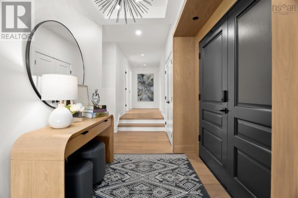 Entryway with a circular mirror, console table, and black double doors. - 2 34 Hazelhurst Street, Dartmouth