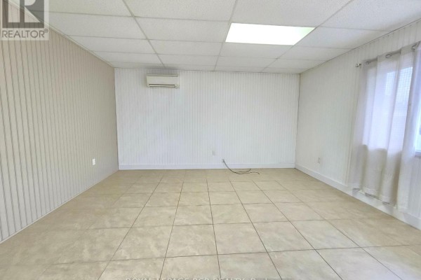 Empty room with tiled floor, white paneled walls, and a window with sheer curtains. - 2-341 Queensville Side Road, East Gwillimbury