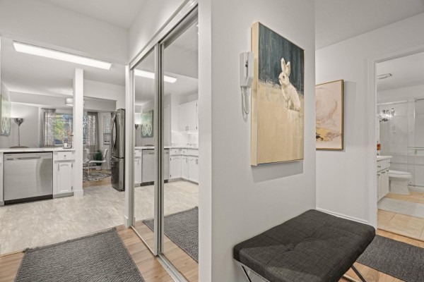 Interior entryway with mirrored closet doors, artwork, and views into the kitchen and bathroom. - 2 7455 Huron Street, Sardis West Vedder, Chilliwack
