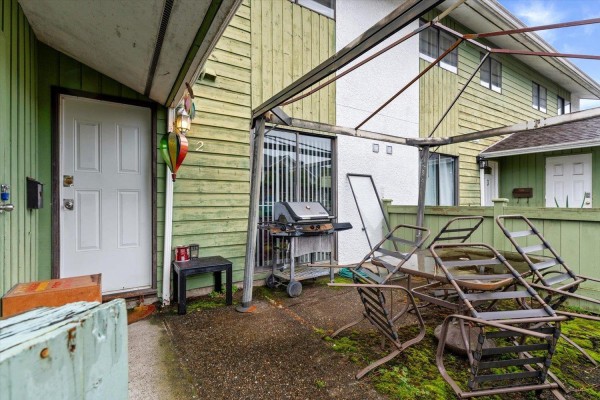 Patio area with grill and stacked chairs under a canopy - 2 9342 Hazel Street, Chilliwack Proper East, Chilliwack