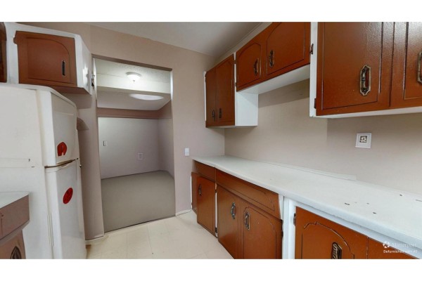 Bedroom with beige walls, carpeted floor, and large window covered with dark curtains - 2 9342 Hazel Street, Chilliwack Proper East, Chilliwack