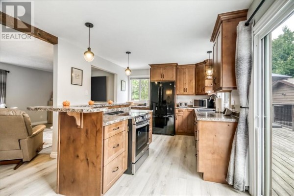 Kitchen with island, wooden cabinets, granite countertops, and deck access - 2 Adam Lively