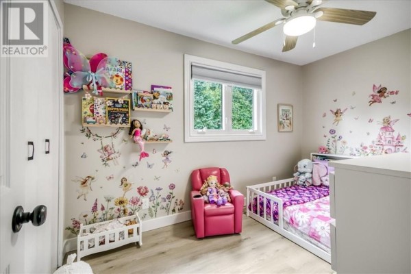 Child's bedroom with fairy tale decals, toddler bed, and pink armchair - 2 Adam Lively